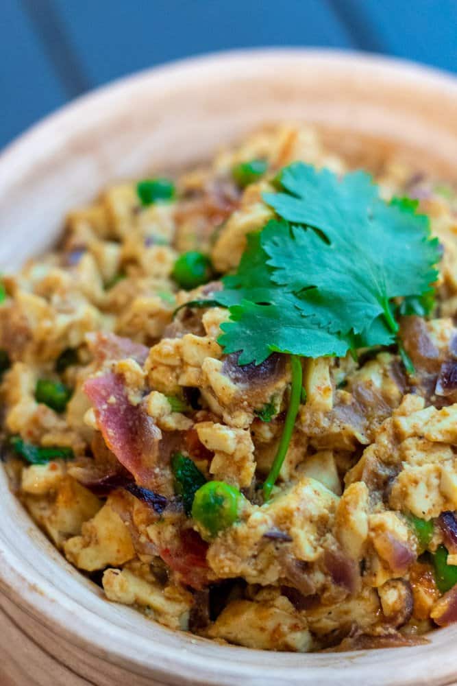 close up image of scrambled tofu matar masala ready to serve in a pot with cilantro on top