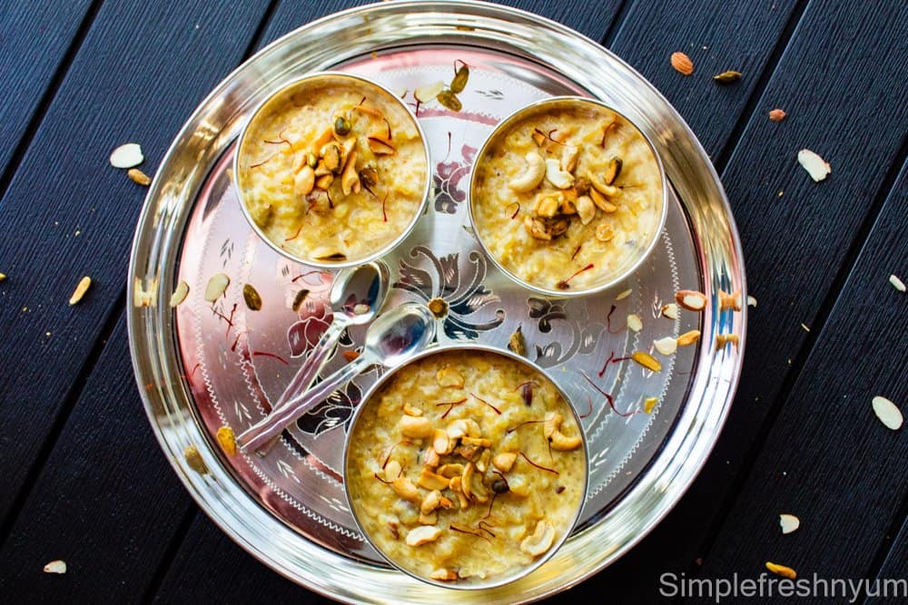 Instant pot Kheer in Silver color bowls on silver color plate with spoons on the side and nuts garnished on top.