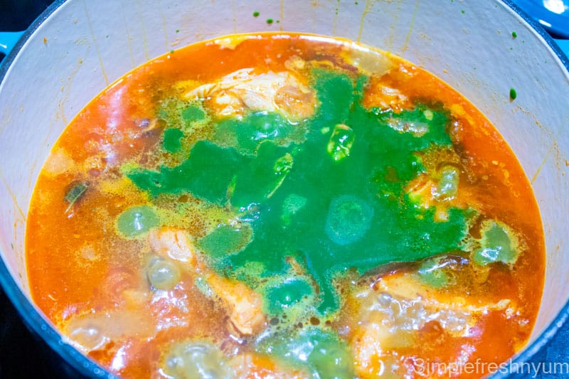 Added spinach puree to the cooked chicken curry in the cooking pot on stove top