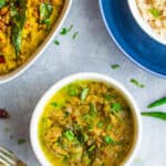 Beerakaya curry in a white serving dish with beerakaya pachadi and brown rice served along with it in separate bowls.